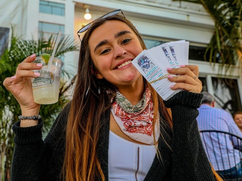 girl-smiling-holding-drink-and-tickets.jpg
